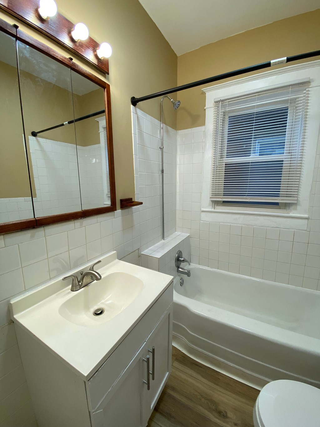 A white sink in a bathroom with a mirror above it.
