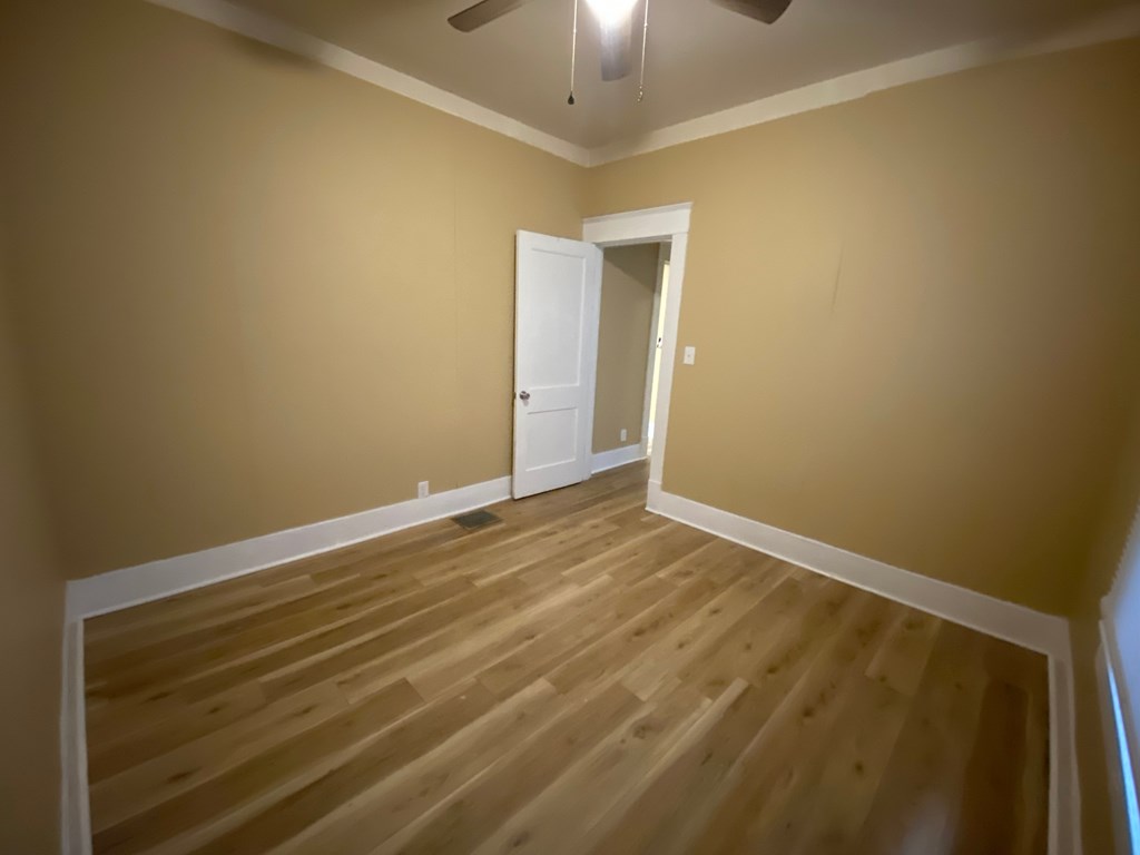 A room with a wooden floor and a white door.
