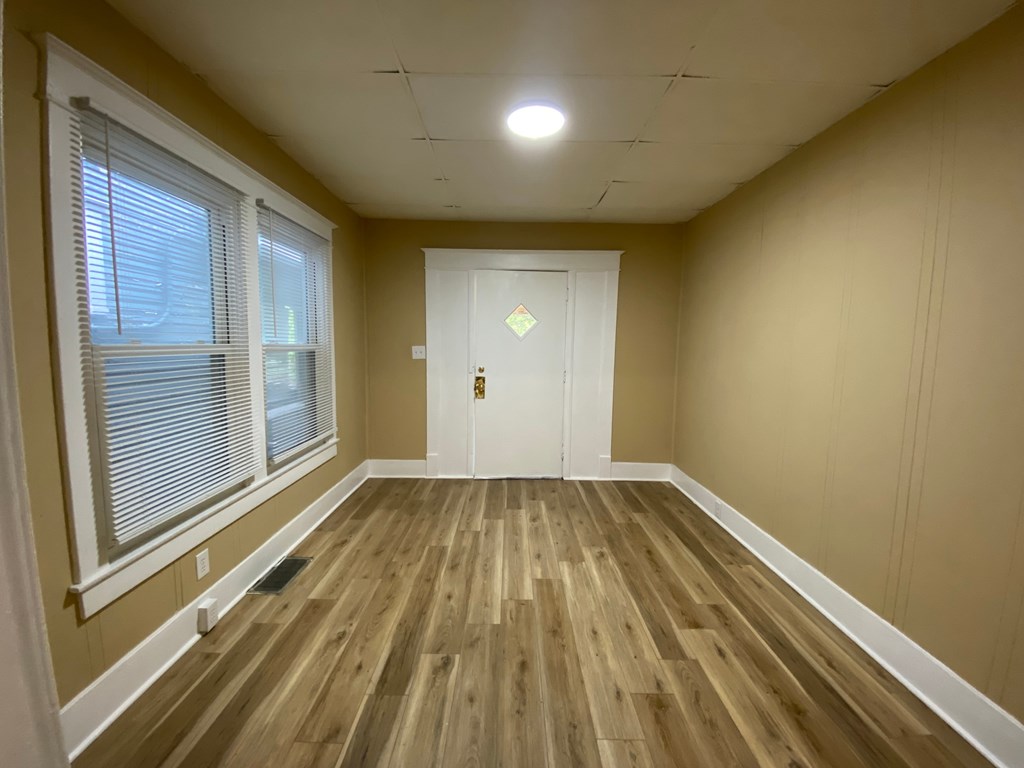 A room with wooden flooring and a white door.