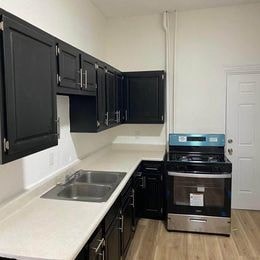 A kitchen with black cabinets and a white countertop.