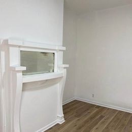 A white fireplace with a glass window in the middle.