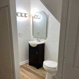 A white toilet sits next to a sink in a small bathroom.