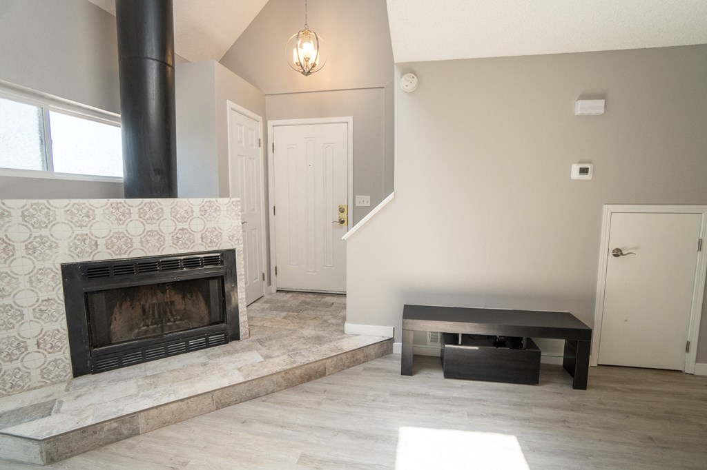 an empty living room with a fireplace and a table