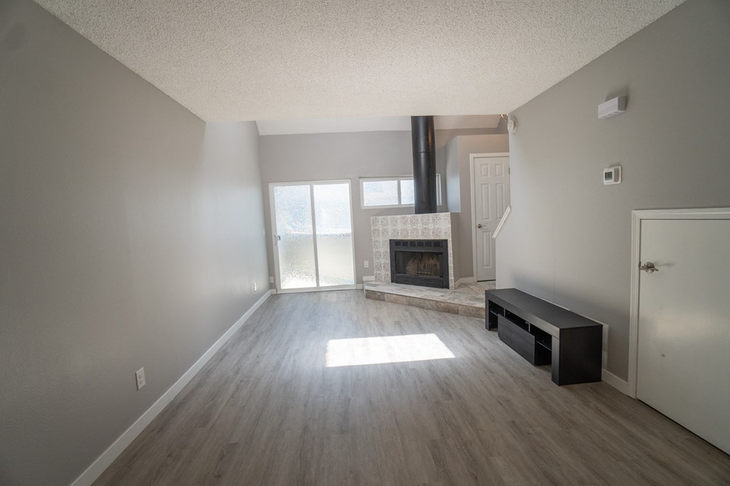 an empty living room with a fireplace and a window