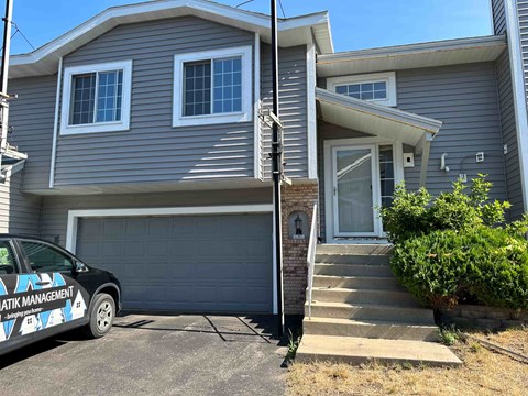 a blue house with a car parked in front of it