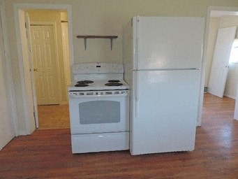 an empty kitchen with a stove and a refrigerator