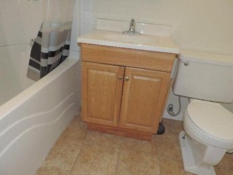a bathroom with a toilet and a sink and a bath tub