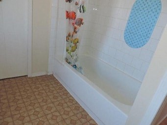 a white bath tub in a bathroom with a shower curtain