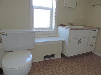 a bathroom with a toilet and a sink and a window