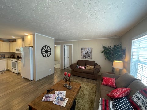a living room and kitchen with a couch and a table