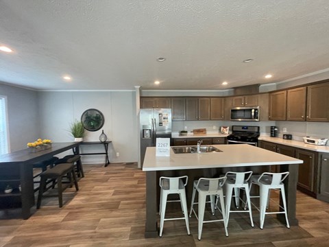 a kitchen with a large island with bar stools