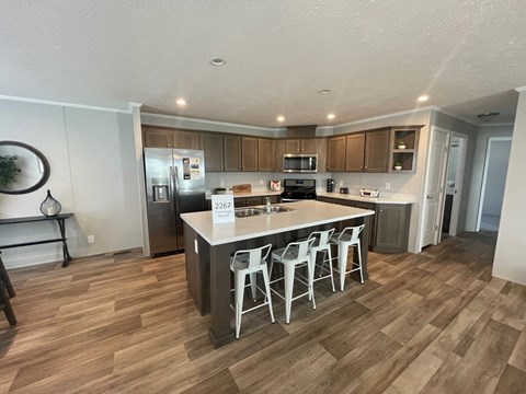a kitchen with a center island with three stools