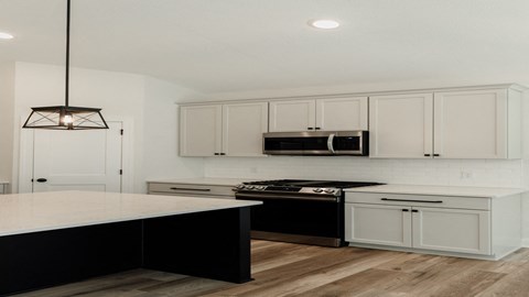 a white kitchen with black appliances and white cabinets