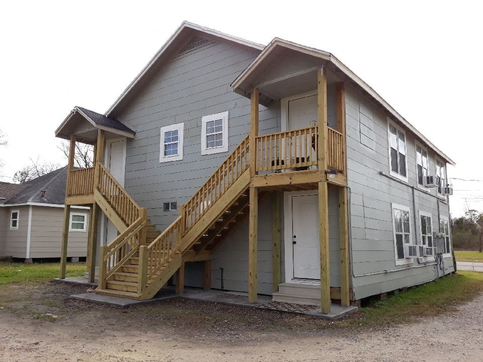 the front of a house with a porch and stairs