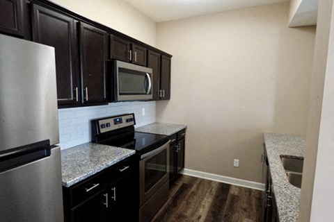 A kitchen with black cabinets and stainless steel appliances.