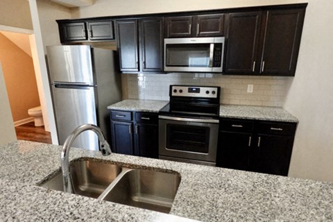 A kitchen with granite countertops and stainless steel appliances.
