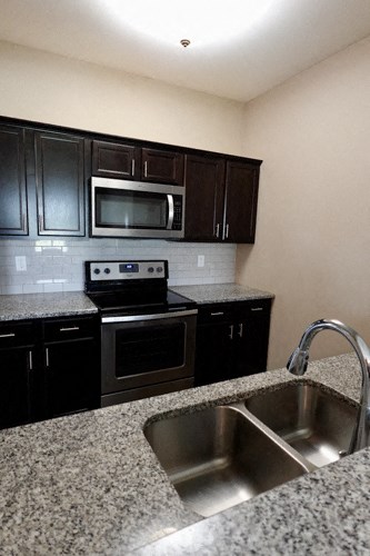 A kitchen with black cabinets and granite countertops.