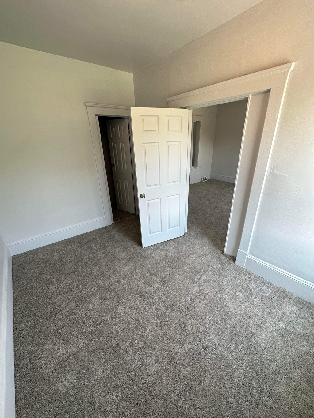 a room with a carpeted floor and an open door