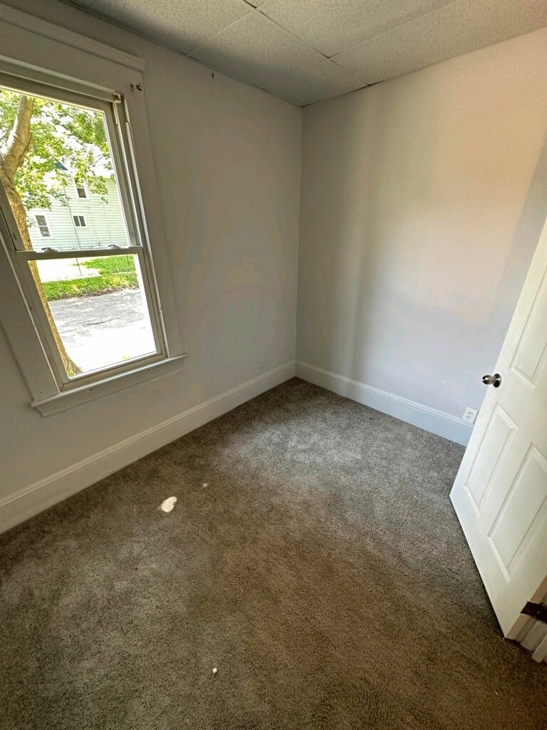 an empty room with a window and a carpet