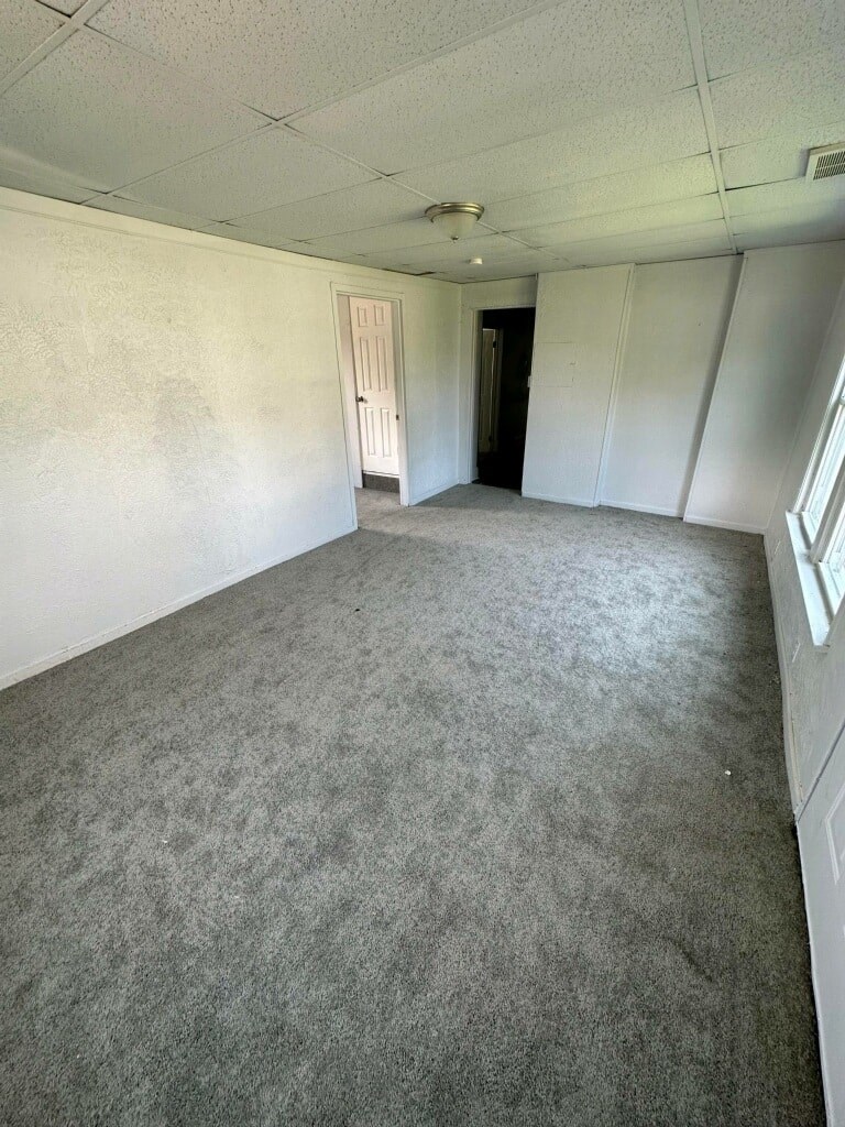 an empty room with a carpeted floor and a door