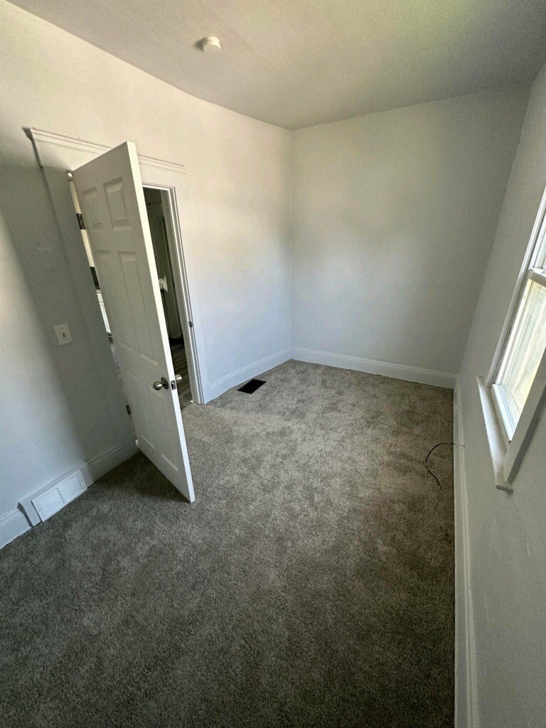 a room with a carpeted floor and an open door