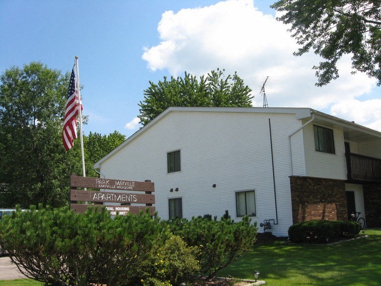 a white building with an flag and a sign