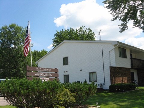 a white building with an flag and a sign