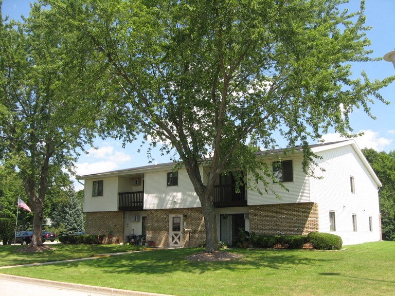 a white house with a large tree in front of it