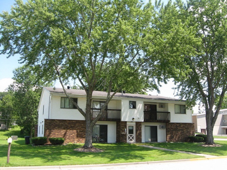 a white apartment building with trees in front of it