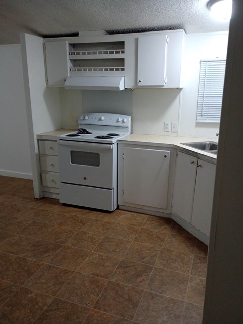 A kitchen with a stove, oven, and cabinets.