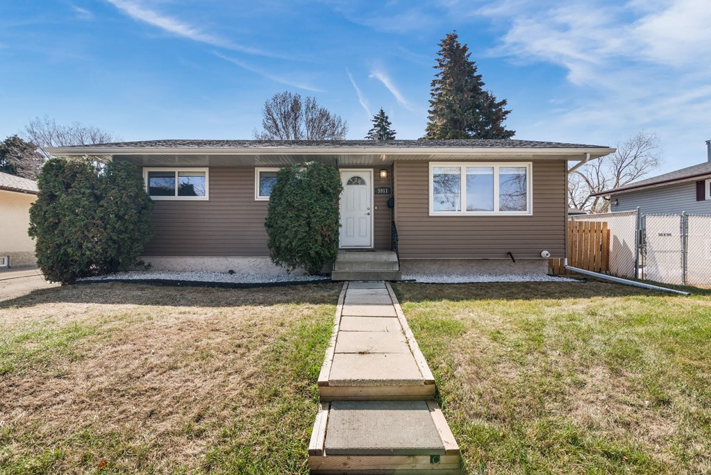 a brown house with a sidewalk in front of it