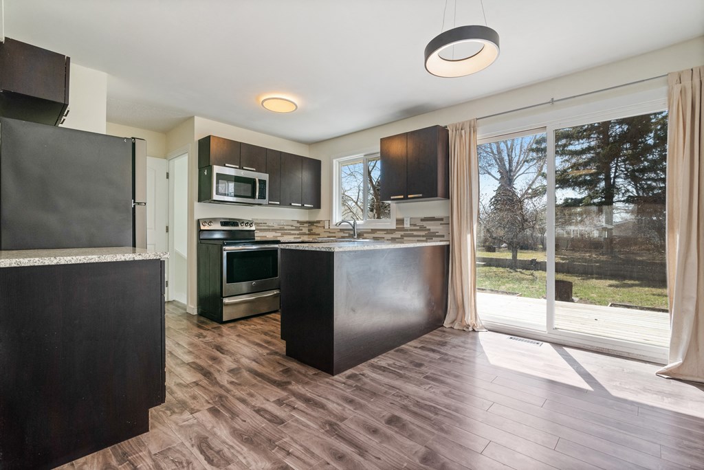 an open kitchen with a large window and a door to a yard