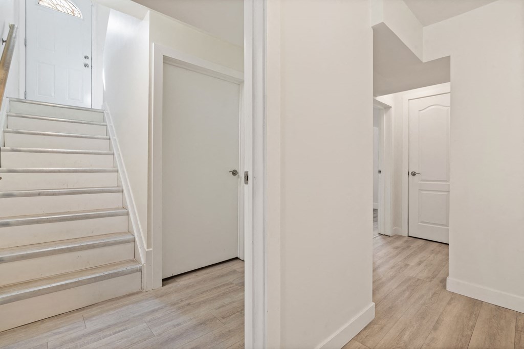 a renovated house with white walls and stairs and a white door