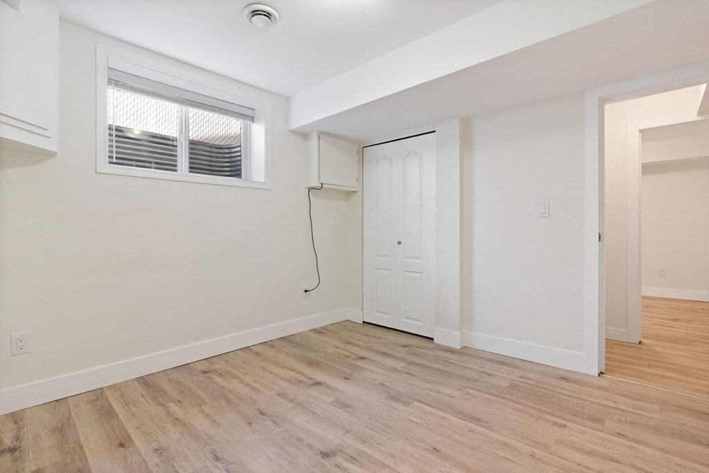 a living room with white walls and a white door and a window