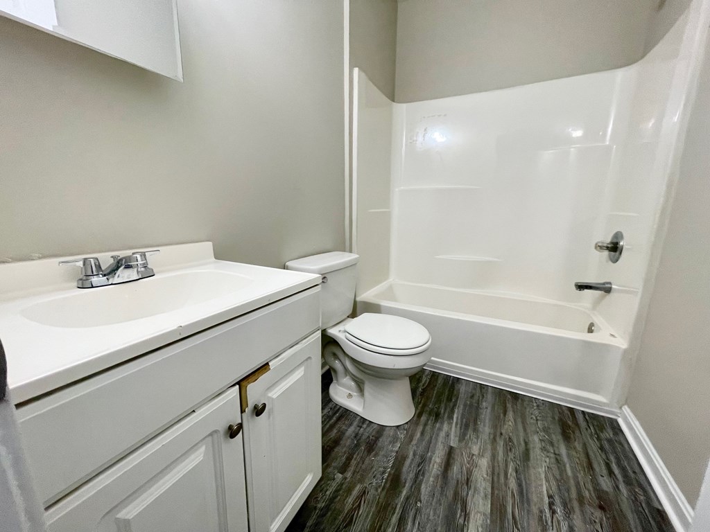A white bathroom with a toilet, sink, and bathtub.