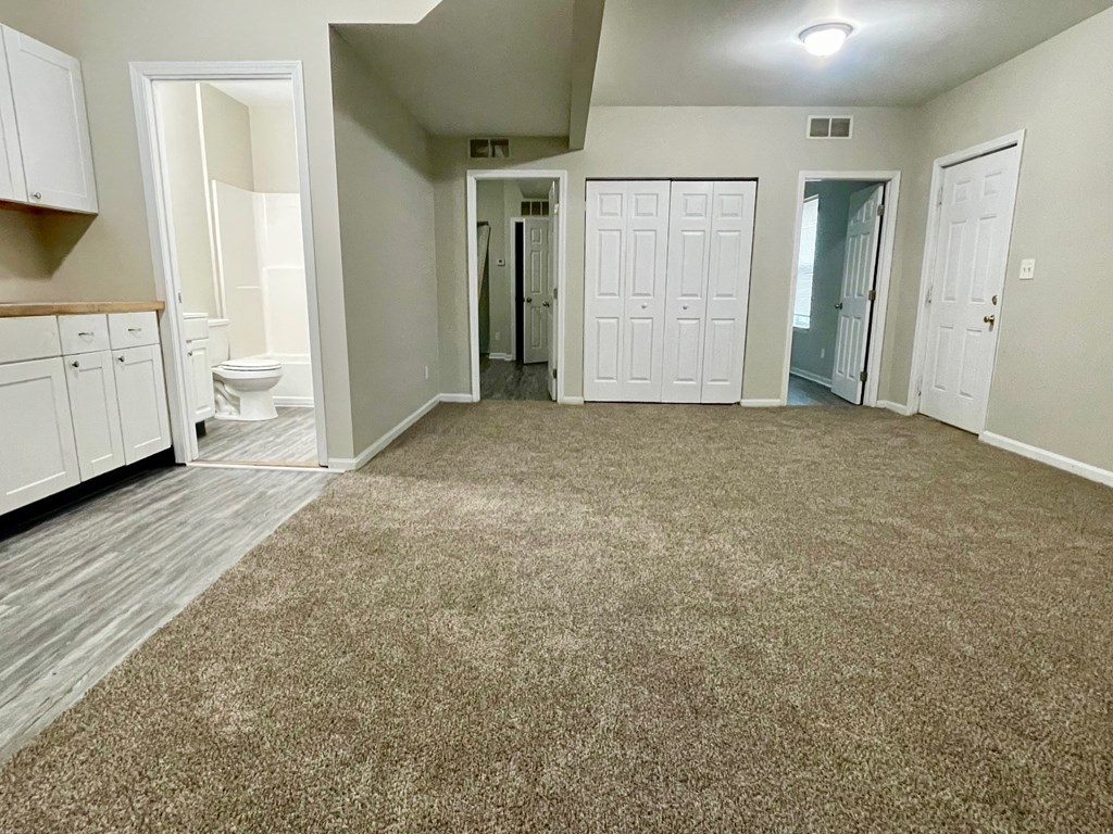 A room with a carpeted floor and white walls.