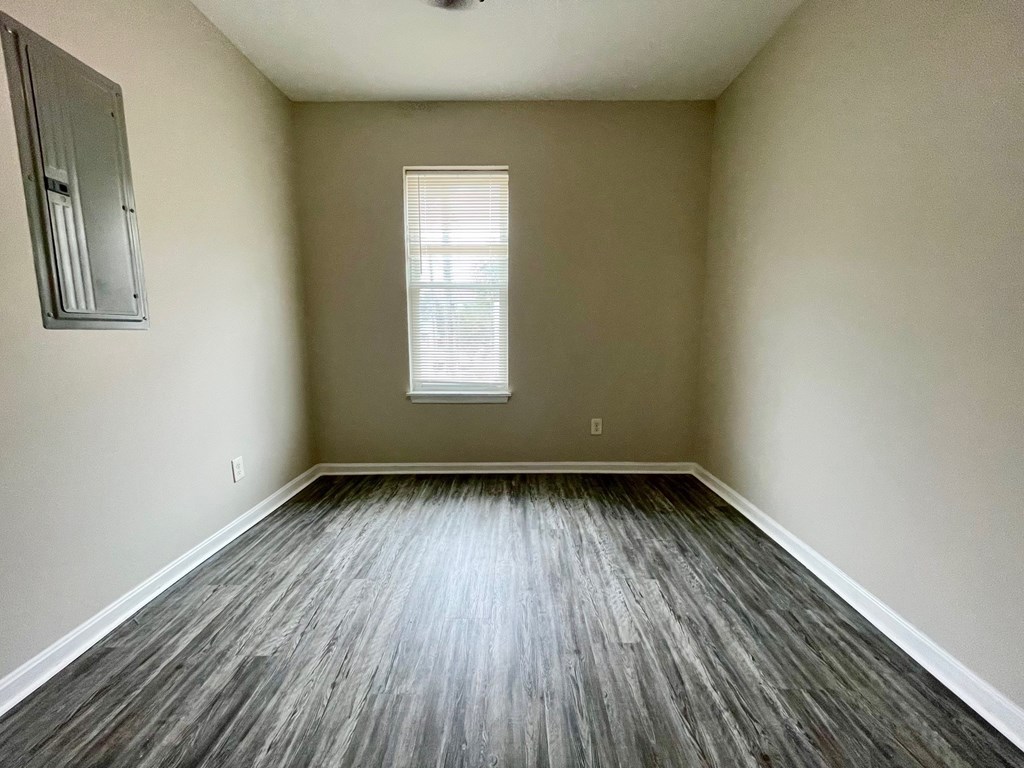 A room with wooden flooring and a window.
