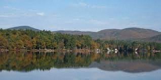 A serene lake surrounded by mountains and trees.