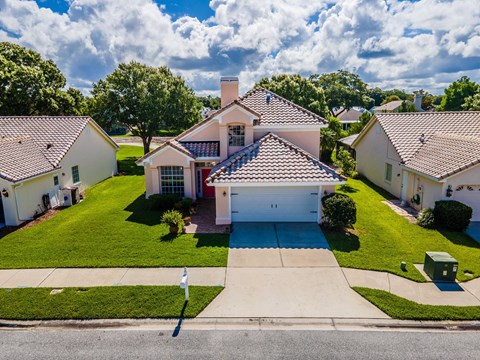 a house with a blue driveway and a green lawn
