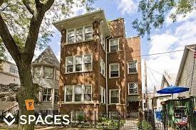 a large brick building with a tree in front of it