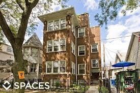 a large brick building with a tree in front of it