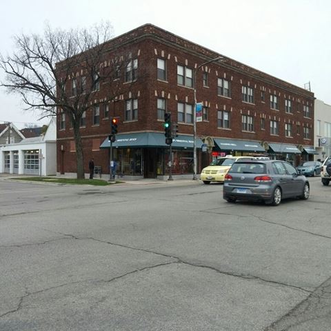 a building on the corner of a street with cars
