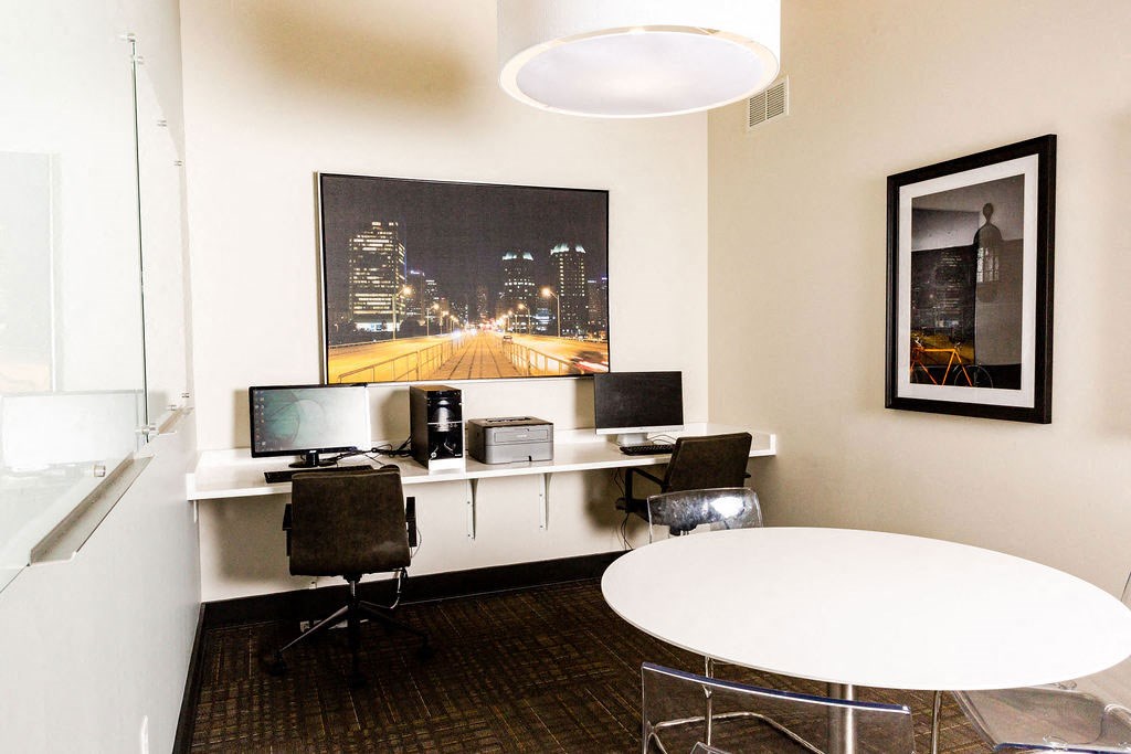 an office with a table and two computer monitors
