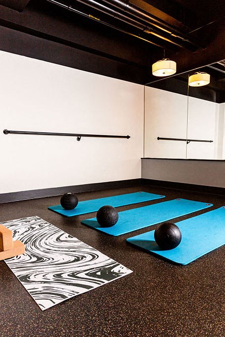 a yoga studio with blue mats and balls on the floor