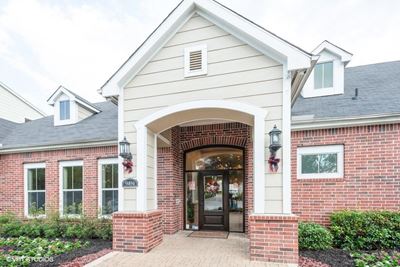 Exterior image of leasing office with lush landscaping on each side of entry way.