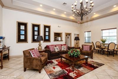 Leasing office setting area with elegant furniture and large chandelier hanging.