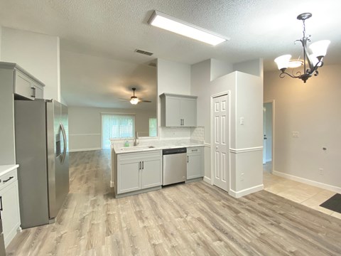 A kitchen with white cabinets and a stainless steel refrigerator.