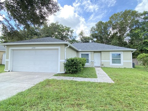 A house with a white garage door and a small front yard.