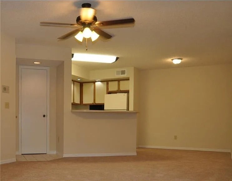 A room with a ceiling fan and a mirror on the wall.