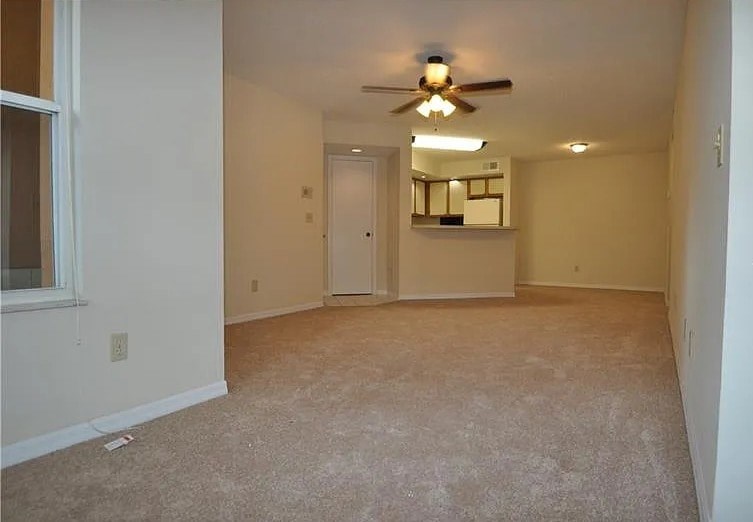 A room with a ceiling fan and a mirror on the wall.